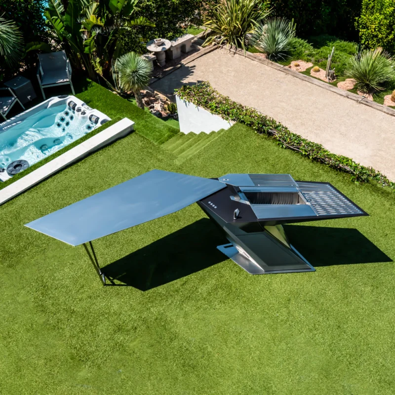 THE LINE Grill with swiveling table in a landscaped outdoor setting THE LINE Grill with swiveling table in a landscaped outdoor setting